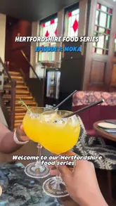 Two creators visit Moka in St Albans for the first episode of their Hertfordshire food series. They provide a tour of the restaurant, showcase the menu, and review several dishes including chicken wings, kebabs, and various curries, while also highlighting the cocktails and the overall dining experience.