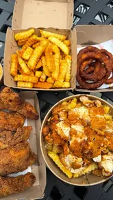 A short, energetic montage showcasing various fried chicken dishes, including wings, fries, and onion rings, presented in takeaway packaging.