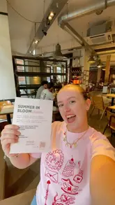 A creator presents a collaboration menu at a Franco Manca restaurant, smiling at the camera in a casual, influencer-style selfie shot.