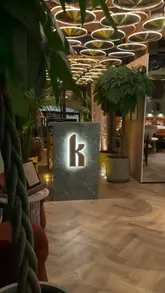 A montage video showcasing the interior and menu of Kobe Mayfair, featuring shots of the dining room, table settings, and various dishes including steak, tartare, and desserts.