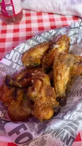 A vlog-style review of The Studio Cafe, highlighting their chicken wings, chips with curry sauce, and fresh scones, while showcasing the venue's retro, Elvis-themed interior.