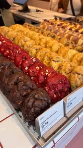 A promotional video for Gooey at Meadowhall, featuring a walk-through of the shop, a display of their cookies and donuts, and close-up shots of the products being enjoyed, including a donut filling reveal and iced matcha drinks.