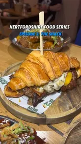 A review video featuring two creators visiting The Shack in Hitchin, showcasing a variety of their menu items including burgers, loaded fries, and wings.