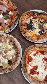 A montage showcasing various pizzas and cocktails at ALFI in Spitalfields Market, highlighting the relaxed atmosphere and the presence of a foosball table.