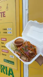 A short promotional video for a food truck called Mucho Picante, featuring close-up shots of their birria tacos being dipped in consommé, alongside a view of their menu board and drink selection.