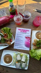 A creator reviews the 'Pink Wednesday' menu at Pho restaurant, featuring £5 dishes like spicy margaritas, summer rolls, and chicken wings, along with a new pink sriracha sauce.