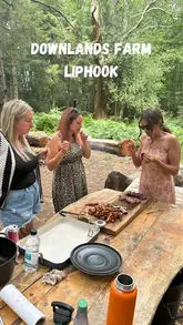 A video showcasing a visit to Downlands Farm, highlighting their regenerative farming practices, including pasture-raised chickens, pigs, and cattle, followed by cooking meat over an open fire in a woodland setting.