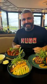 A review of The White Pheasant restaurant at the Golf Links Hotel in Portrush, featuring a variety of dishes including chicken wings, a salmon rice bowl, a pork chop, and cheesecake.