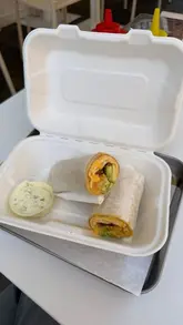 A short promotional video showcasing a new breakfast burrito offering at a London burger restaurant, featuring shots of the food, the venue interior, and the kitchen preparation.