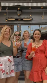 A group of friends visits Flight Club, enjoying cocktails and food on the terrace before heading inside to play darts.