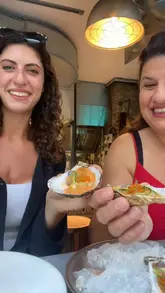 A short video showcasing a variety of Spanish tapas dishes, including oysters, prawns, croquettes, tomato bread, and a dessert, enjoyed by two people in a restaurant setting.