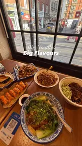 A review of Q Beef Noodles featuring various noodle dishes, a lamb burger, and chicken dumplings. The video includes behind-the-scenes footage of the noodle-making process and the creator's reactions to the food.