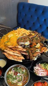 A promotional video showcasing a large mixed grill platter, various appetizers like samosa chaat and gol gappay, and colourful mocktails at Tawa Grill.