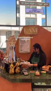 A short, montage-style video showcasing a Saudi-French cafe and retail pop-up located within the Selfridges Corner Shop in London. The video features close-ups of coffee, pastries, and various retail items including makeup, chocolate, and accessories.