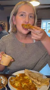 A couple visits a country pub for a curry night, showcasing the exterior, the menu, and their meal of samosas, pakoras, chicken rogan josh, and lamb bhuna.