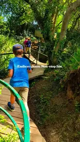A bright, outdoor lifestyle shot capturing a child walking along a wooden trail at an adventure park, effectively conveying a sense of fun and exploration.