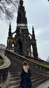 A travel-focused shot featuring a person walking towards the Scott Monument in Edinburgh, Scotland, capturing the city's iconic gothic architecture.