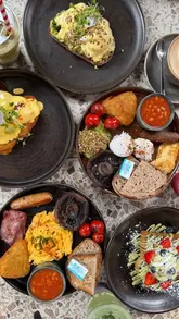 A short, aesthetic montage showcasing brunch dishes and drinks at Milk & Egg in West Ealing, featuring items like Eggs Benedict, avocado toast, pistachio French toast, and a blueberry matcha latte.