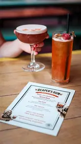 A promotional video for Edinburgh Street Food, focusing on their collaboration with Reaper's Rum. The video features quick, well-lit shots of cocktails being prepared and served, alongside close-ups of street food dishes like burgers and mac and cheese bites, set to music with a voiceover explaining the venue's suitability for drinks and socialising during the Fringe festival.
