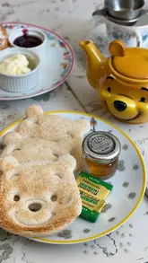 A charming, thematic shot of Winnie the Pooh-themed toast and tea at Pooh Corner, capturing a whimsical and nostalgic cafe experience.