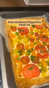 A home cooking tutorial demonstrating how to make a honey and mustard whipped feta tomato tart using store-bought puff pastry and fresh tomatoes.