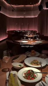 A cinematic, slow-paced montage showcasing the interior and food offerings of a London restaurant, focusing on its suitability for a date night.