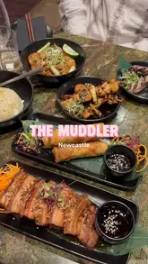 A short montage showcasing various Asian fusion dishes and cocktails at The Muddler in Newcastle, featuring close-up shots of pork belly, spring rolls, and skewers.