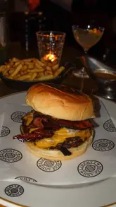 A review of the limited-edition Calfreezy x Hawksmoor burger collaboration, featuring the burger, fries, and drinks in a restaurant setting.