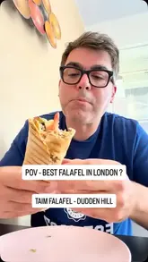 A creator visits a small, newly opened falafel shop in Dudden Hill, London, to support a local business. He interviews the owner, orders a falafel wrap and hummus, and provides an honest review of the food and the experience.