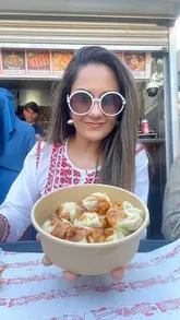 A vibrant vlog-style tour of a Bangladeshi food court in Upton Park, featuring the creator exploring various stalls and sampling authentic dishes like Fuchka, Momos, and Kacchi Biryani.