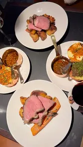 A high-quality review of the Sunday roast at Lennox in Edinburgh's West End, featuring close-ups of the dry-aged striploin, creative sides like oxtail ragu-stuffed Yorkshire pudding, and a smoked banana custard tart dessert.
