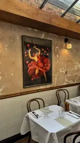 A montage of a French bistro in West Hampstead, showcasing the interior, signature cocktails, and a variety of dishes including duck confit, steak, and chocolate mousse.