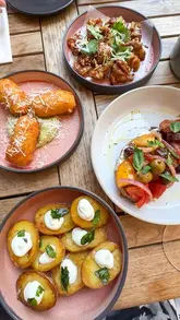 A short reel showcasing a lunch experience at Coppa Club in Marylebone, featuring outdoor seating, a selection of small plates, and wine.