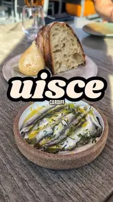 A review of Uisce by Heaneys in the Pontcanna neighborhood of Cardiff, highlighting its identity as a low-key oyster and wine bar with a Spanish-influenced small plates menu. The creator samples several dishes, including pickled anchovies, hash browns, and truffle fried chicken, while providing context about the chef and the venue's background.
