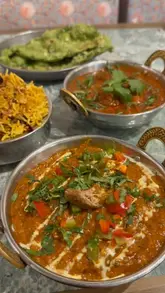 A series of static, high-quality shots showcasing various Indian dishes, including curries, rice, and appetizers, served at Namaste Village.