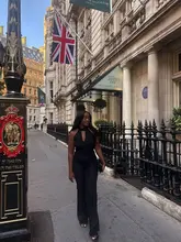 A stylish lifestyle photograph featuring a woman walking in front of the entrance to The Royal Horseguards Hotel and The Twenty One Restaurant & Bar in London, capturing an elegant, aspirational aesthetic.