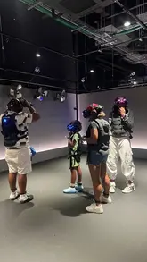 A group of people, including a child, visit Sandbox VR to try out a virtual reality gaming experience. The video captures the process of gearing up with VR equipment, the immersive gameplay, and the fun atmosphere of the venue.