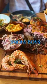 A review-style video where a creator and his father visit a new BBQ restaurant in Bromley, showcasing various dishes including a BBQ platter, smash burger, and sides.