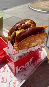 A visually focused video showcasing brioche sandwiches, fries, and iced drinks at Loaf. The video uses quick, handheld shots to highlight the texture and presentation of the food, creating an appealing, casual vibe suitable for a quick lunch or brunch spot.