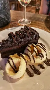A montage video showcasing a visit to Table 23 in Upminster, featuring shots of a large sharing platter, wine, the restaurant interior, live entertainment, and dessert.