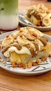 A short, aesthetic montage showcasing the interior of a coffee shop and their monthly special banoffee cinnamon bun.