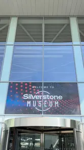 A straightforward, eye-level shot of the entrance to the Silverstone Museum, featuring the venue's branding on the glass facade. The image serves as a clear, functional establishing shot for a family-friendly day out.