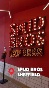 A short video showcasing the preparation and final presentation of loaded jacket potatoes at Spud Bros in Sheffield, featuring staff assembling the dishes and a customer enjoying the meal.