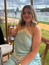 A candid lifestyle shot of a woman enjoying a drink inside a marquee at a racecourse event, capturing the atmosphere of a social day out.