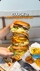 A promotional video for Cluck'd in Leicester, featuring a variety of grilled chicken dishes, loaded fries, and sides, alongside shots of the restaurant's interior and ordering kiosks.