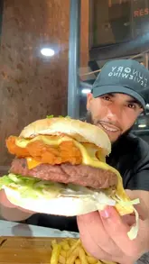 A creator reviews a new burger at The Woodlands in Blackburn, highlighting the ingredients like grass-fed Angus beef and fried chicken.
