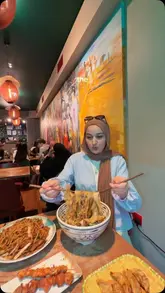 A vlog-style video featuring two creators visiting a popular noodle restaurant in London, showcasing the hand-pulled noodle process and their meal.