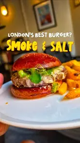A creator reviews a monthly special burger at a restaurant, focusing on the taste, texture, and the quality of the house-made bun and accompanying fries.