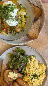 A short, handheld vlog-style reel showcasing a visit to Crème & Co in Hamilton, featuring interior shots, the menu, and brunch dishes like scrambled eggs and iced lattes.