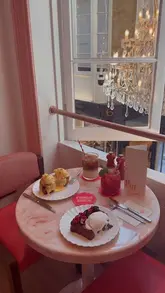 A polished, aesthetic montage showcasing the interior and menu of Le Café by Nicolas Rouzaud in London. The video features slow, deliberate shots of the cafe's pink and red decor, the chandelier, the pastry display, and various brunch items like Eggs Benedict and Brioche Glacée.